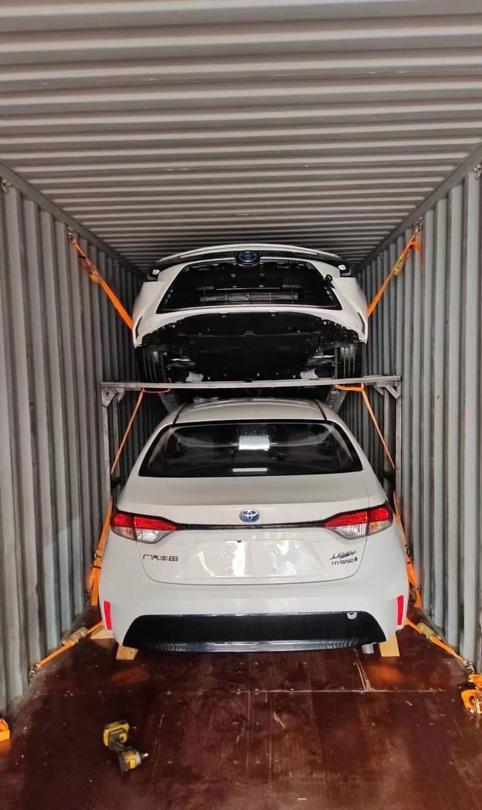 Two Toyota Corolla hybrids loaded in a container